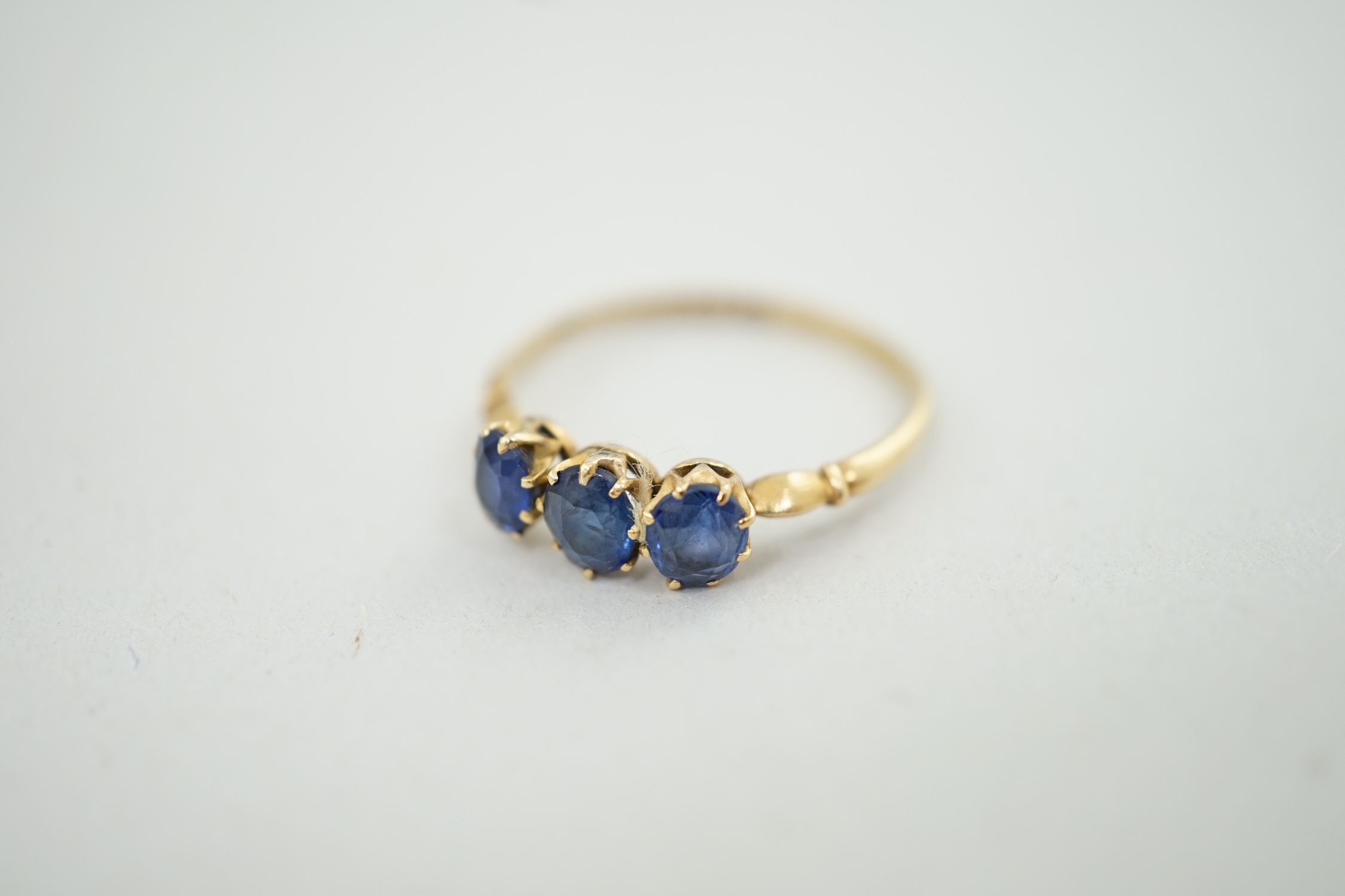 A late Victorian 18ct gold and three stone oval cut sapphire set ring, size P/Q, gross weight 1.9 grams. Condition - fair